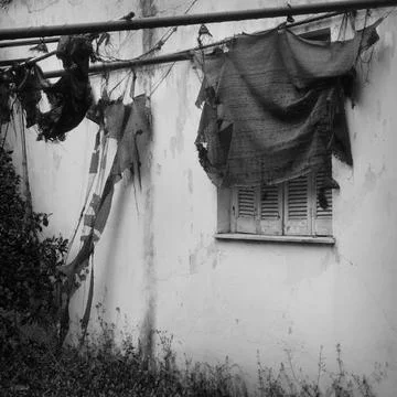 Torn tent and window shutter in abandoned house Foto stock