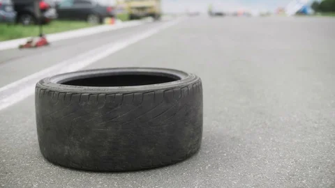 Torn tire lying on a side of road. Screw jack on background. Police car pulls up Stock Footage 129345842