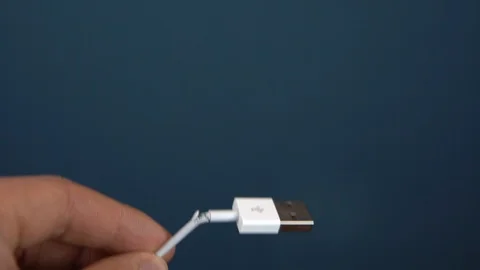 Torn USB cable close-up. A man holds a torn wire in his hands. Wire wear Stock Footage 121205577