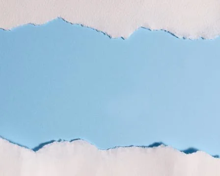Torn white paper creating border on light blue background with empty copy space Foto stock