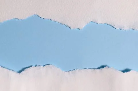 Torn white paper creating border on light blue background with empty copy space Foto stock