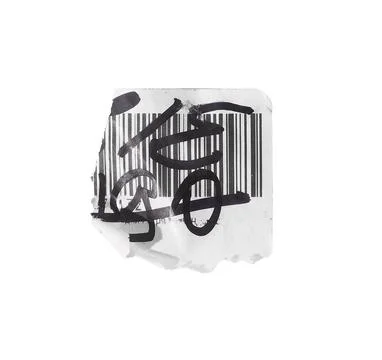 Torn white paper label with printed barcode and bold black marker scribbles a Stock Photos