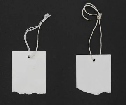 Torn white paper labels with thread tie Stock-Fotos