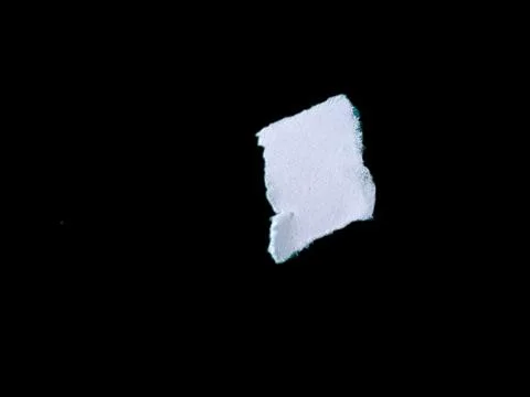 Torn White Paper Piece on Solid Black Background with Rough Edges Stock Photos