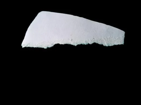 Torn White Paper Piece on Solid Black Background with Rough Edges 스톡 사진