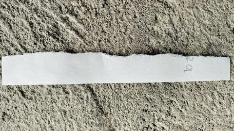 Torn White Paper Strip on Rough Gray Concrete Texture Background Stock Photos