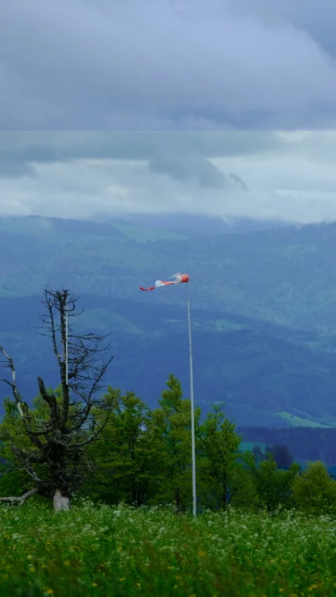 Torn windsock with storm on the mountain in the background 스톡 동영상 278099969