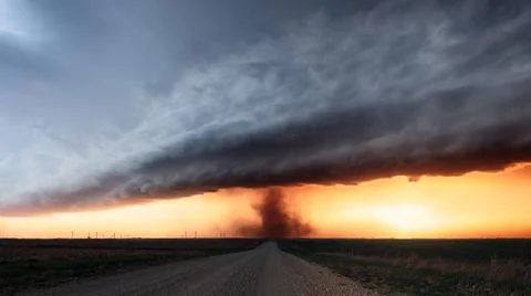 Tornado and dark storm clouds at sunset Stock Photos