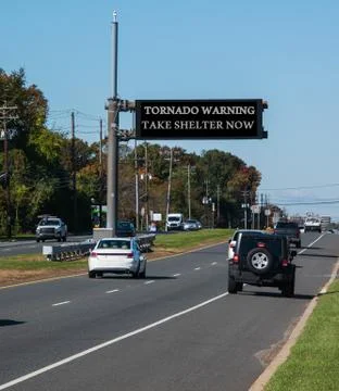 Tornado warning take shelter now, electronic warning sign over highway Stock Photos