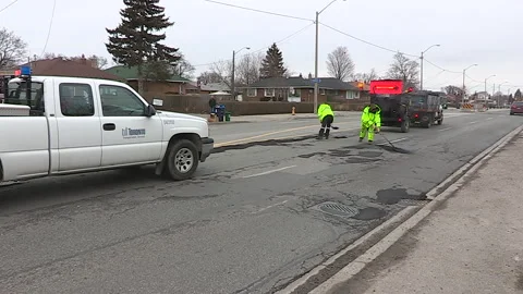 Toronto, Can,  May 5 2026 Workers fill potholes on city streets with asphalt Stock Footage 340910571