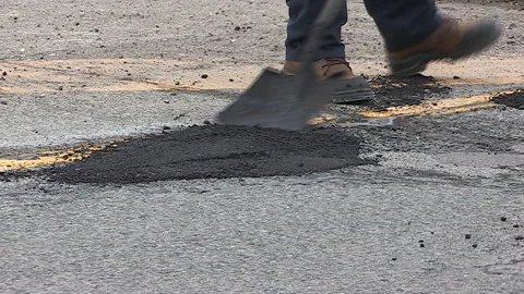 Toronto, Can,  May 5 2026 Workers fill potholes on city streets with asphalt Stock Footage 340910583