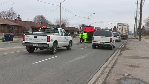Toronto, Can,  May 5 2026 Workers fill potholes on city streets with asphalt Stock Footage 340910593
