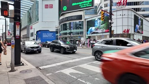 TORONTO, CANADA - 2024 August 4 :  traffic in front of Eaton cener and H&amp;M Stock Footage 280943071