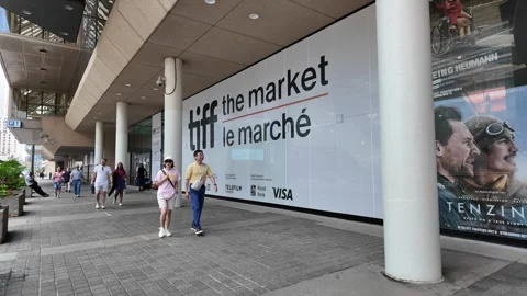 TORONTO, CANADA - 2026 September 5: people passing by TIFF the market sign Stock Footage 344774009