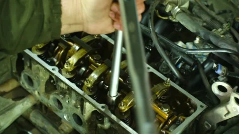 Torque wrench clicks as technician secures engine cylinder head bolts to Stock Footage 310521129