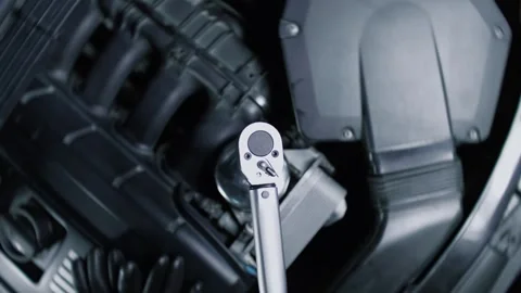 Torque wrench in operation under the hood of a racing car in car service center Stock Footage 340581113