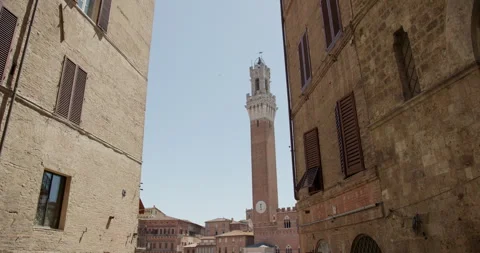 Torre del Mangia framed by medieval buildings in historic Siena, Tuscany, Italy Видео 340588442