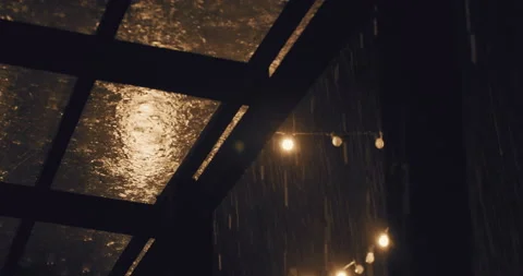 Torrential storm rain fall on transparent roof of terrace at night Video stock 224560588