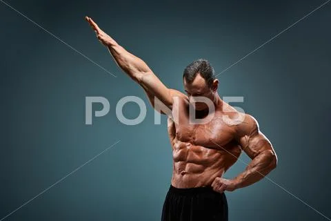 Torso of attractive male body builder on gray background ~ Hi Res #68975293