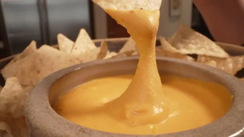 Tortilla chip dipped in queso cheese macro 動画素材 221361516