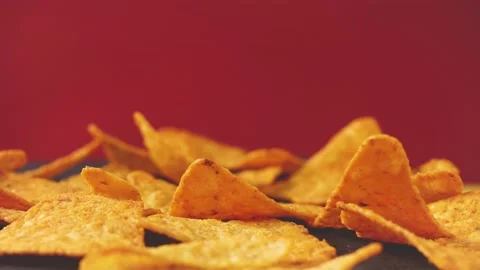 Tortillas chips rotate on red background. Yellow triangle shaped tortilla chips  Video stock 149660166