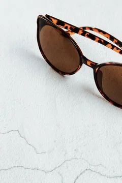 Tortoise shell sunglass frames on a white surface Stock Photos