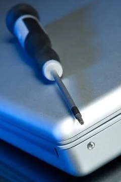 A torx screwdriver sits on a laptop computer Stock Photos