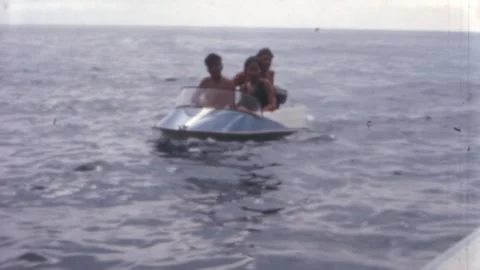 Tossa de Mar - 1966: group of friends ride in old tiny vintage boat in summer Stockbeeldmateriaal 269940202