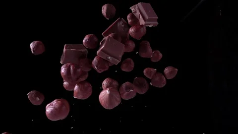 Tossed chocolates and hazelnuts Stock Footage 129906658