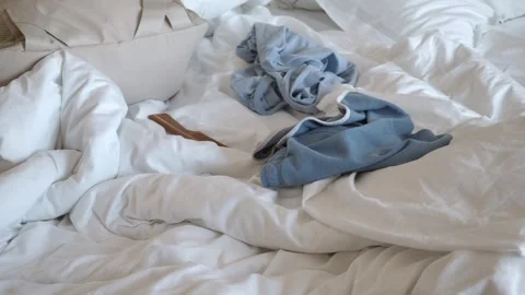 Tossed clothes on a messy bed in a bright room Stock Footage 326289105