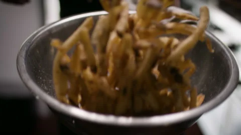 Tossing and seasoning freshly fried fries. Stock Footage 134502204