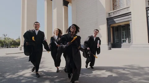 Tossing up and throwing academic cap in mid air. Happy Friends on graduation Stock Footage 116186224