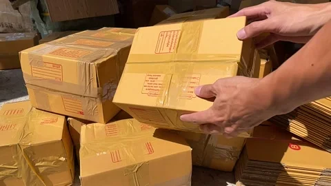 Tossing brown box package to pile of parcel boxes slow motion on a sunny day Stock Footage 225125859
