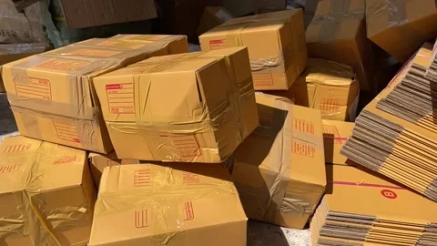 Tossing brown box package to pile of parcel boxes slow motion on a sunny day Stock Footage 225125863