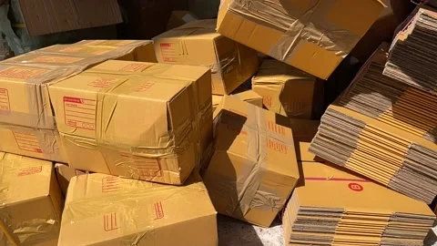 Tossing brown box package to pile of parcel boxes slow motion on a sunny day Stock Footage 225126140