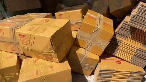 Tossing brown box package to pile of parcel boxes slow motion on a sunny day Stock Footage 225126210