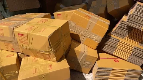 Tossing brown box package to pile of parcel boxes slow motion on a sunny day Stock Footage 225126245
