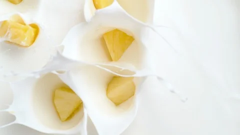 Tossing cut pineapple in milk. Overhead shot. Slow Motion. Stock Footage 94078691