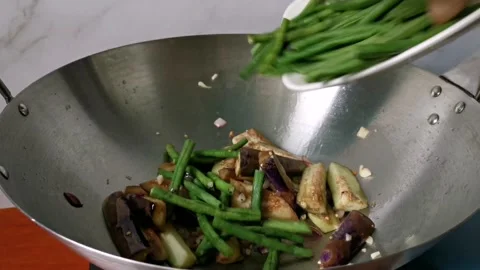 Tossing Long String Beans on Chopped Vegetables in a Wok Stock Footage 234882196