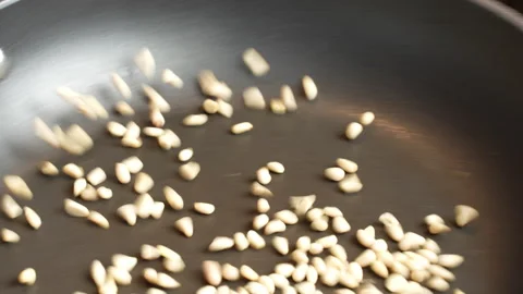 Tossing pine nuts in a skillet while roasting, Video stock 302020749