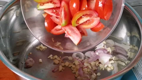 Tossing Sliced Tomatoes inside a Casserole Stock Footage 159291204