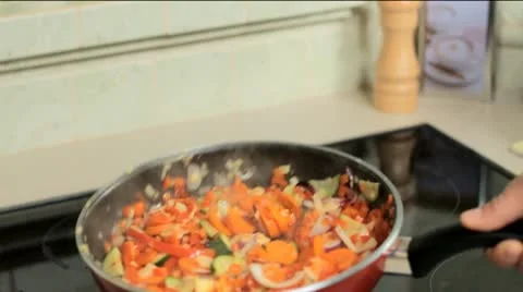 Tossing vegetables in a pan Stock Footage 12760597