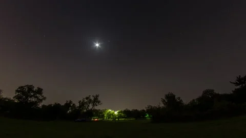 Total lunar eclipse turning to a blood moon over a field timelapse Vídeos de archivo 154941737