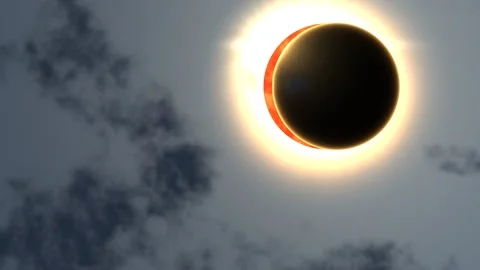 Total solar eclipse in cloudy sky with bright diamond ring effect. 4K Video stock 343243867
