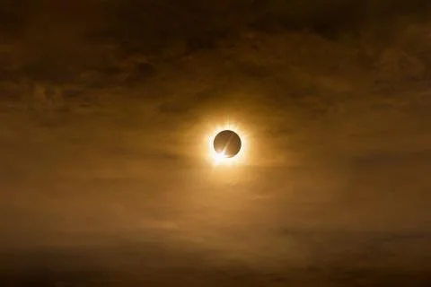 Total solar eclipse in dark red cloudy sky Stock Photos