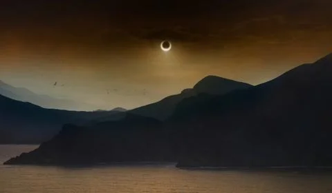 Total solar eclipse in dark red sky above sea and mountains Stock-Fotos