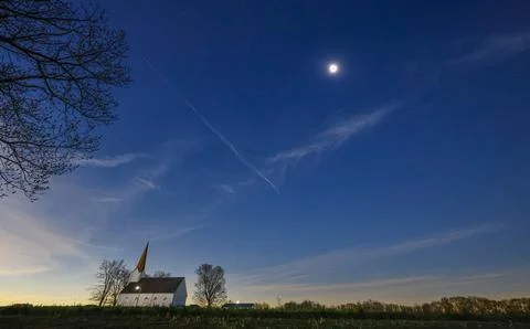 Total solar eclipse over a church in the country. Stock Photos