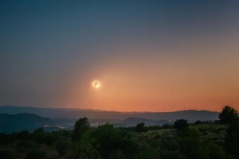 Total Solar Eclipse over Hills and Wind Farm Stock Photos