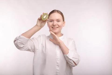 Touch hands to face. Cut a slice of kiwi. Kiwi juice in care cosmetics Stock Photos