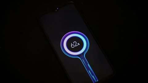 A touch screen mobile cell phone is quick charging against dark background in Stock Footage 139360414